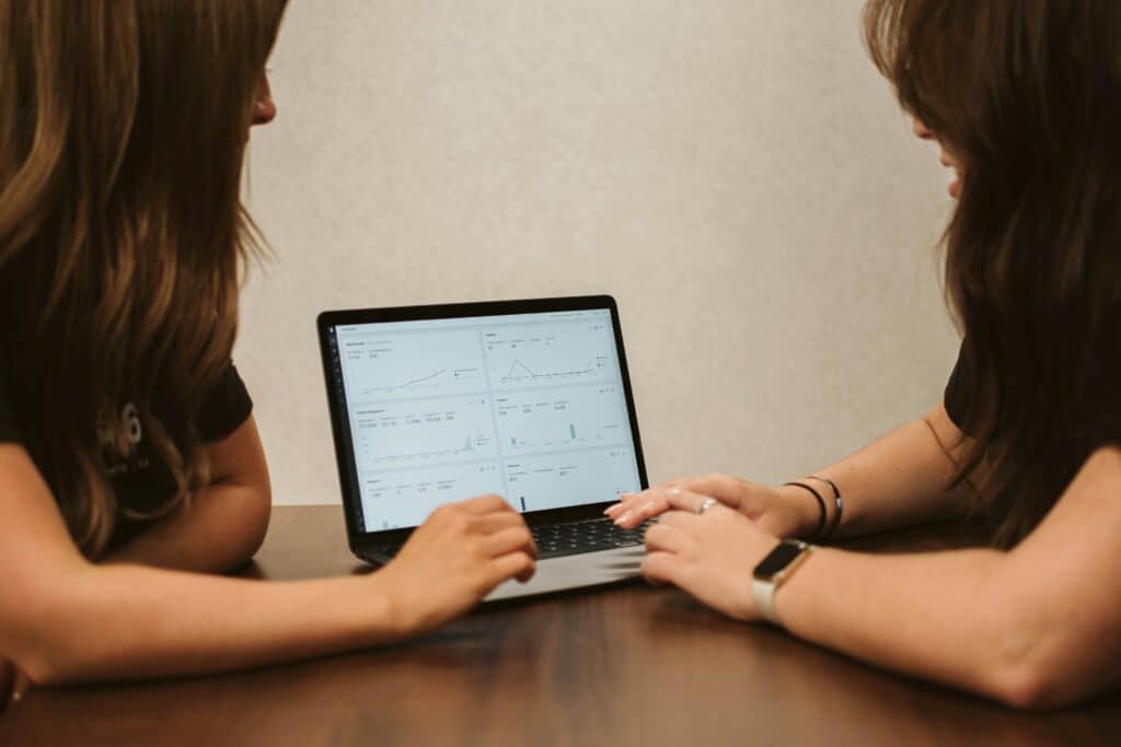 women looking at a laptop and market insights data