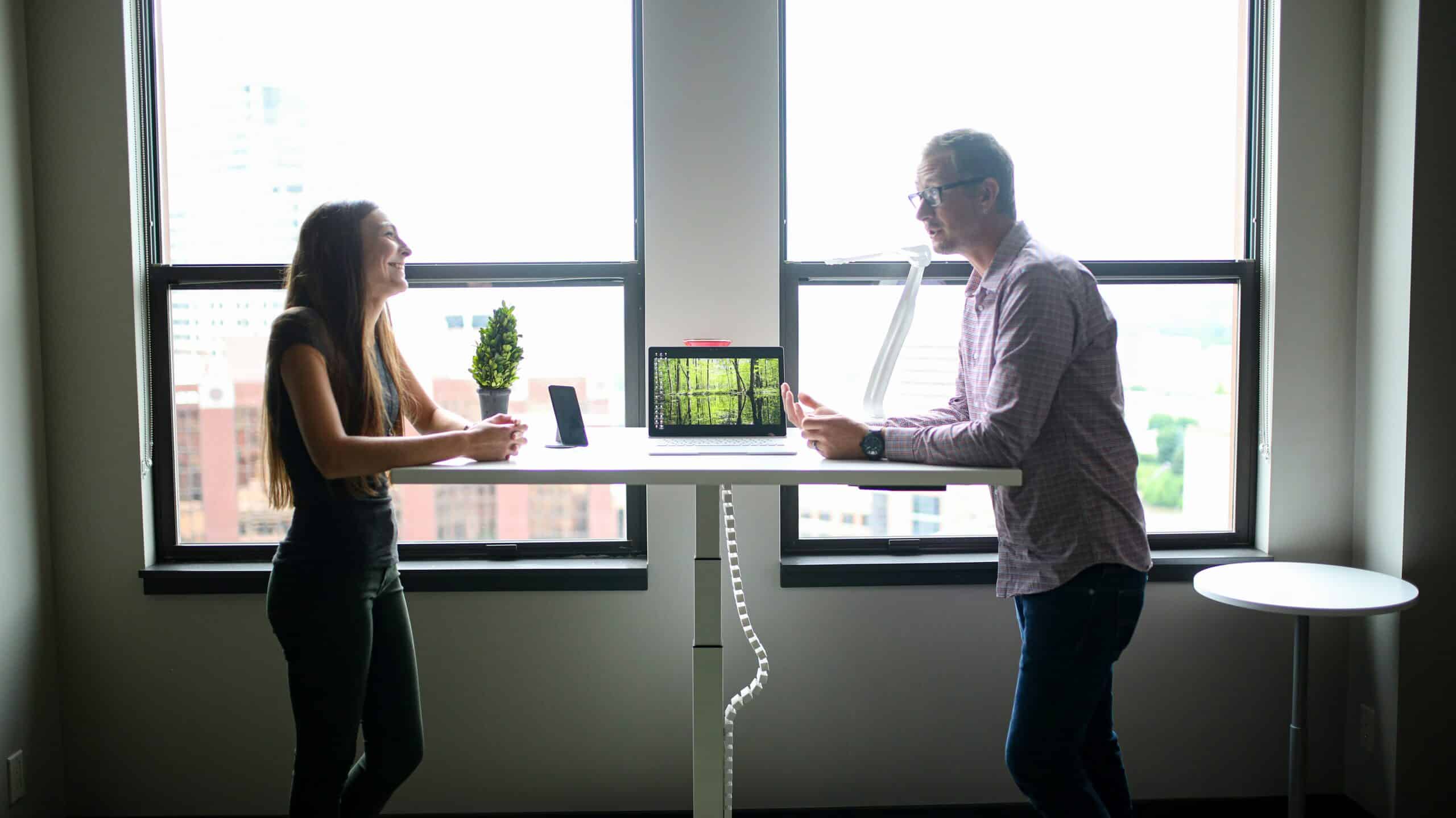 a man and woman on a standing desk speak over a HubSpot