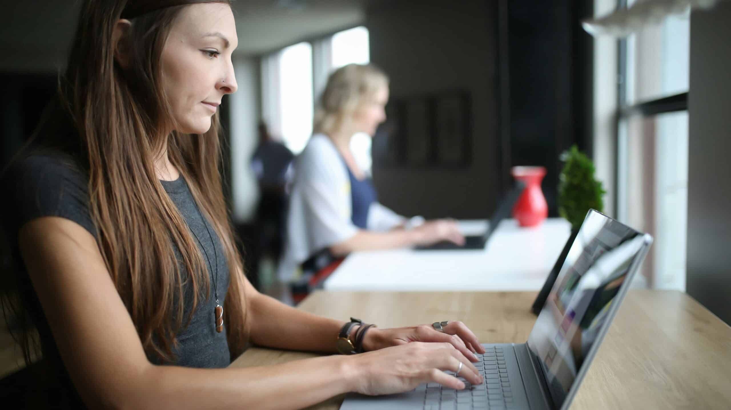 woman looks at her laptop working on enterprise knowledge management