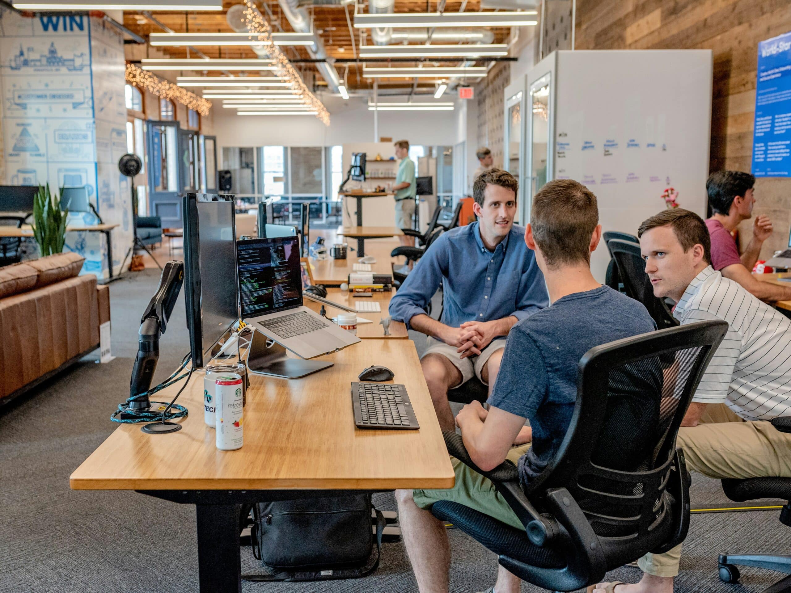 Three men in an office look at a screen for AI in knowledge management solutions