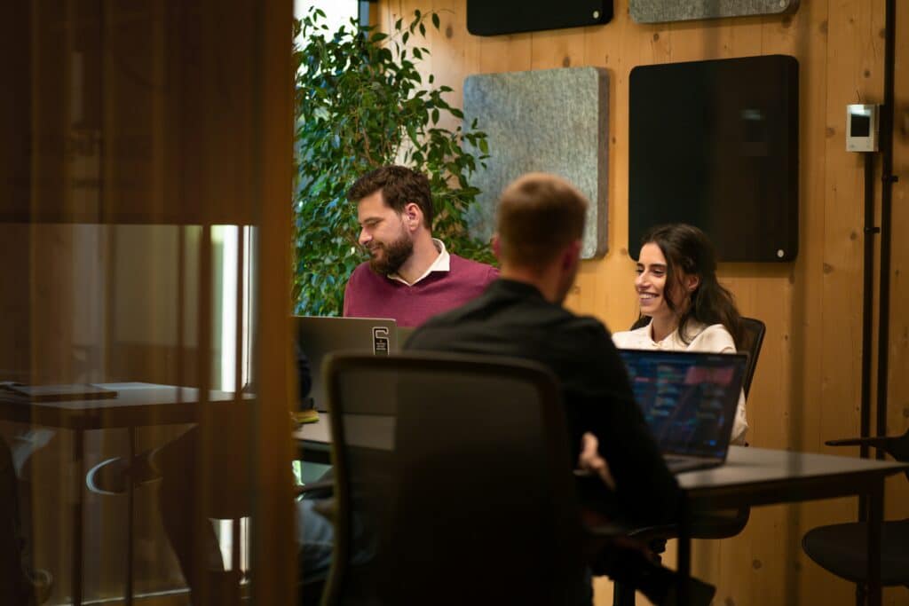 three people at a meeting discussing market research