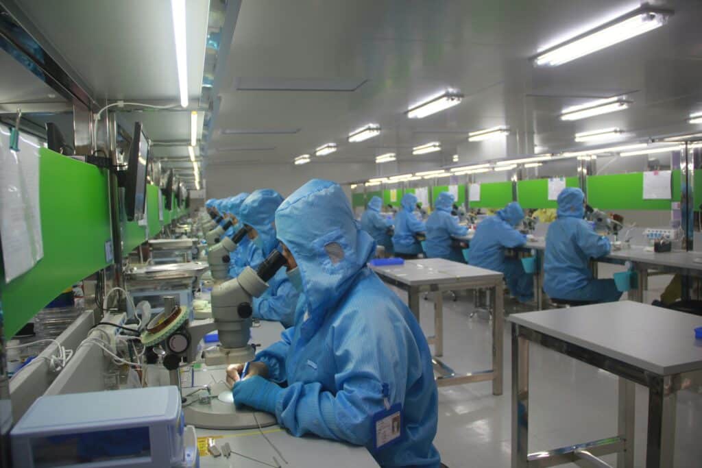 people in blue lab coats in a lab 