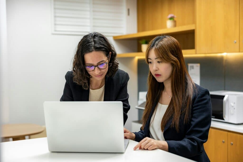 two women sitting at desk with laptop researching unstructured data management tools