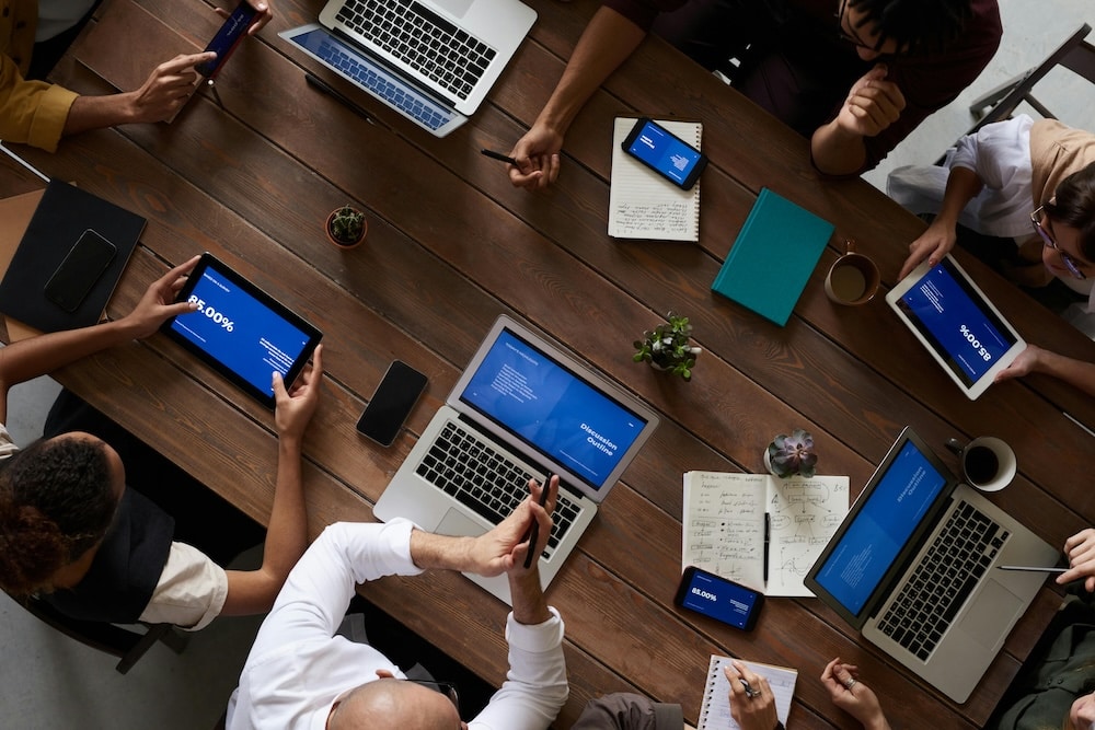 people sitting down at their laptop and working toegther looking at sources of market research data