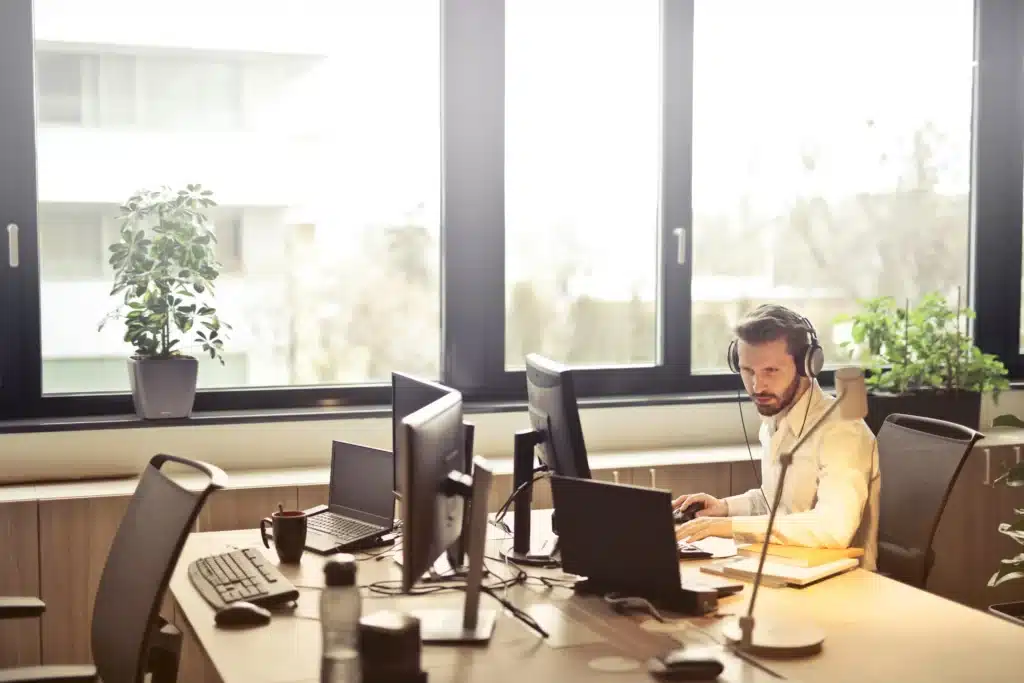 Person at a desk and laptop is analyzing patterns across diverse data sources simultaneously to detect emerging trends, a direct solution to the problem of fragmentation