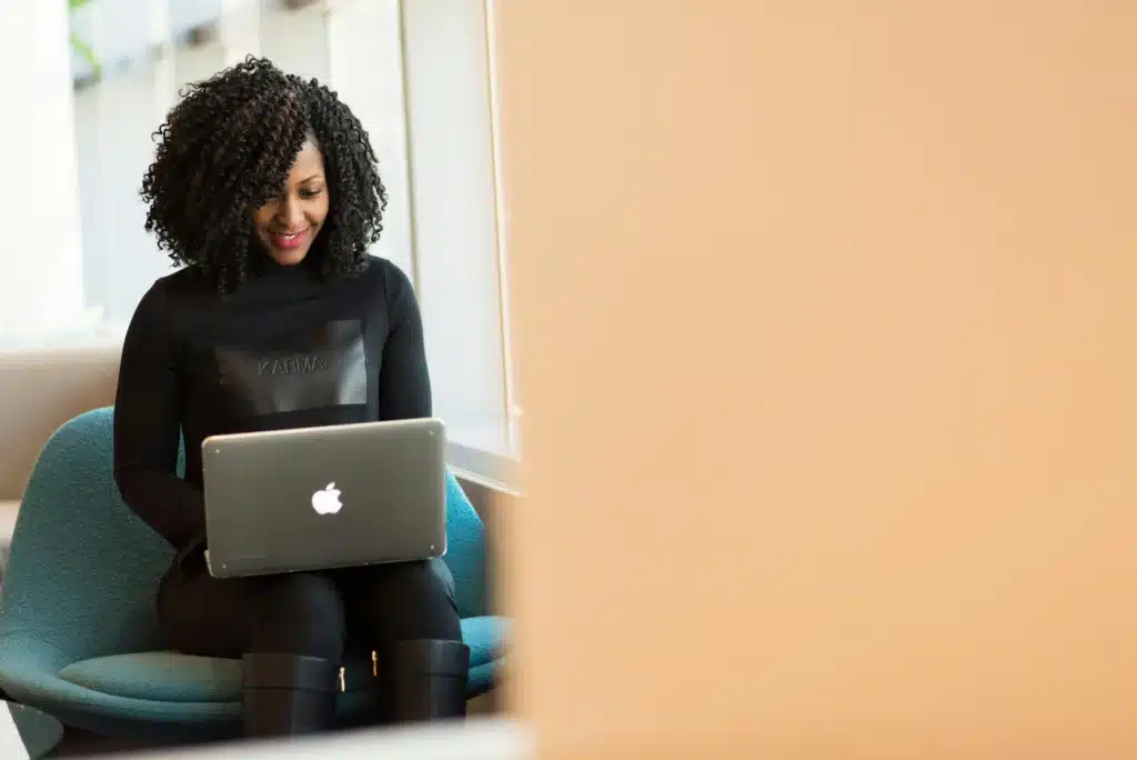 A woman at her laptop working on retrieving customer experience data with access to an AI-powered customer insights platform