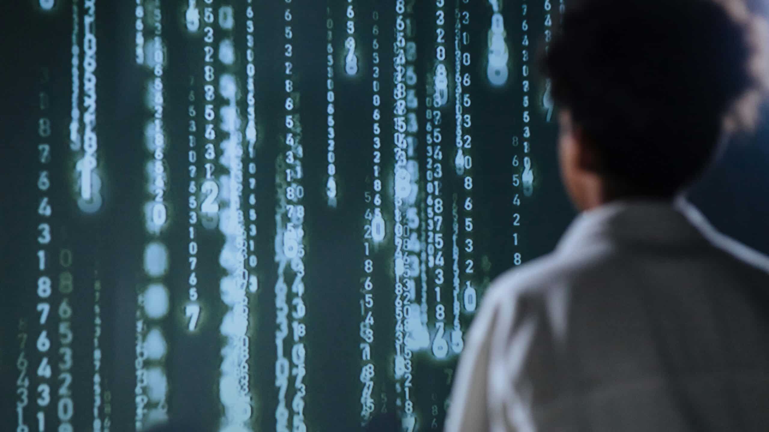 Person facing a Big Screen with Numbers representing Agentic AI and humans working together